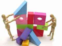 積み木の家を人形が解体しているイメージ写真